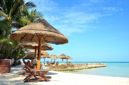 Chairs and umbrella on a beach with shadow from palm treeの写真素材