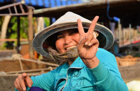 CAN THO - VIETNAM - MARCH 5 2015 Woman in blue in hat showing victory signのeditorial素材