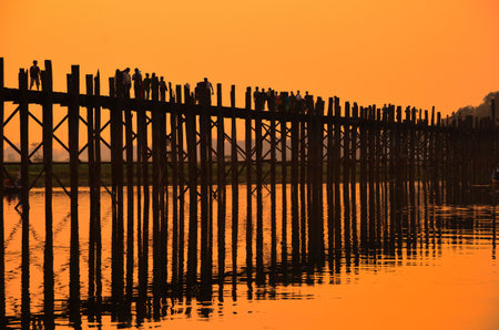 Amarapura, Myanmar - 14 March 2015: People walking on the wooden bridge of U Bein on river Ayeyarwad, Myanmarのeditorial素材