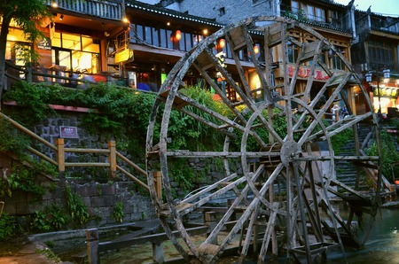 Fenghuang, China - May 15, 2017: Old water wheel in food court on riverside near Phoenix Hong Bridge in Fenghuangのeditorial素材