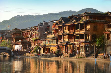 Fenghuang, China - May 15, 2017: Old building with people in food court on riverside near Phoenix Hong Bridge in Fenghuangのeditorial素材