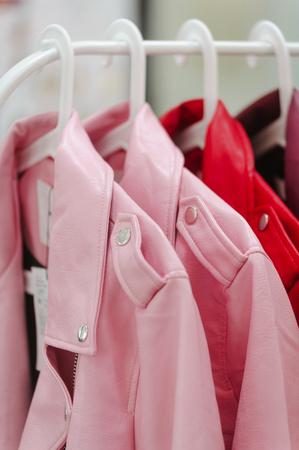 Leather womans jackets is on sale in shop at hanger pink and red colorsの写真素材