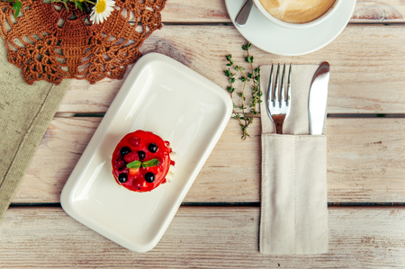 rustic breakfest with cappuccino and sandwich on wooden table with fork and knifeの写真素材