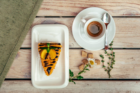rustic breakfest with coffee and cake on wooden table with fork and knife. decorated with chamomile...