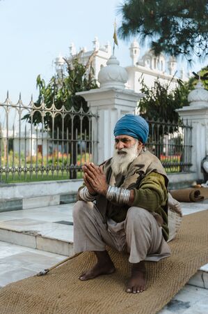 old indian sikh praying nearby golden temple. 26 february 2018 Amritsar, India.のeditorial素材