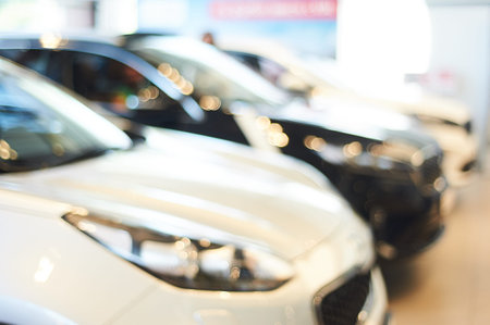 modern car showroom. blurred automobile hoods. not in focus background. copy space