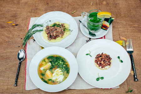 full dinner for one person with few dishes at wooden table background