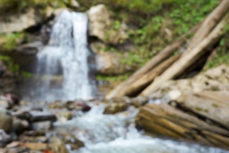 blurred waterfall spring background. beatiful nature with fresh green plants and water.の写真素材