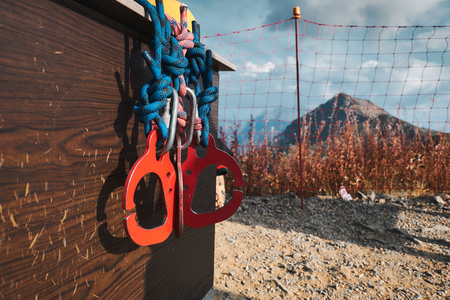 red carabines at scratched at mountain background. climbing safety system equipment. Copy spaceの写真素材