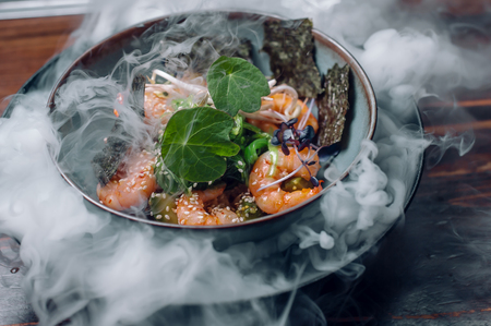 prawn salad with avocado, sea kale and sesame in ice vapor. high kitchen serving conceptの写真素材