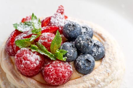 meringue nest with blueberry and raspberry. Sweet dessert.の写真素材