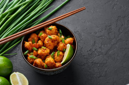 Gobi Manchurian in bowl at black concrete background. Gobi Manchurian is Indian Chinese cuisine dish...