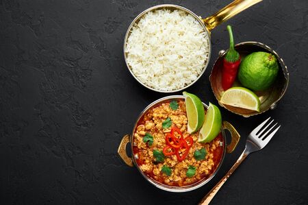 Chicken keema in traditional indian copper kadai at dark slate background. Kheema is indian and pakistani cuisine curry dish with minced meat and spices. Copy space. Top viewの写真素材