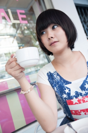 Girl in a coffee shop on a bright day の写真素材