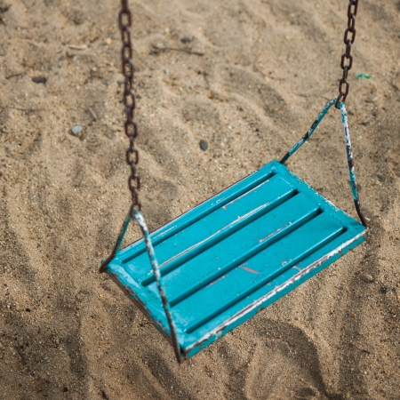 Blue swing at the playground on a clear dayの写真素材