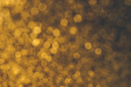 Gold Festive Christmas background. Elegant abstract background with bokeh defocused lights and starsの写真素材