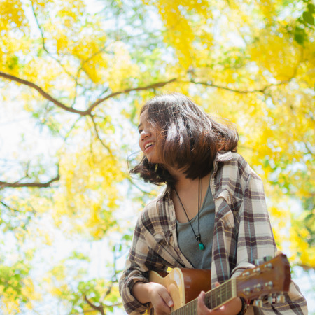 Musician woman and her guitar in good dayの写真素材