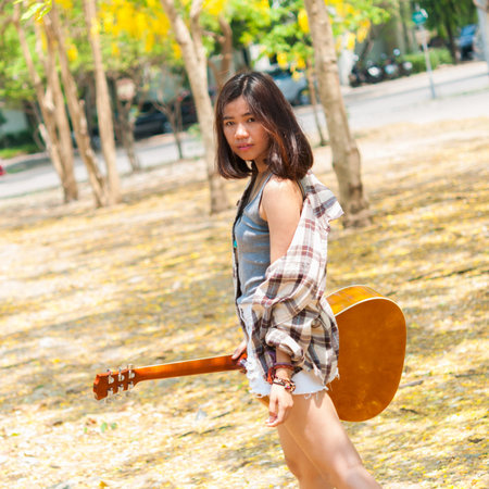 Musician woman and her guitar in good dayの写真素材