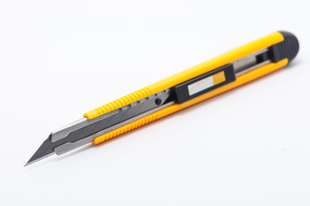 The yellow stationary knife isolated on white background