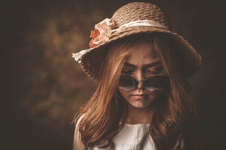 Young woman in white shirt with her hat on a old background, Retro effectの写真素材