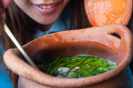Woman cooking and smelling soup from her meal in a potの写真素材