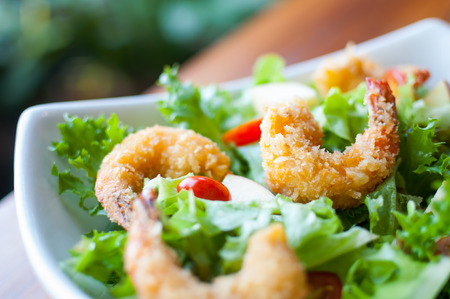 Healthy green salad with fried shrimp in a bowlの写真素材