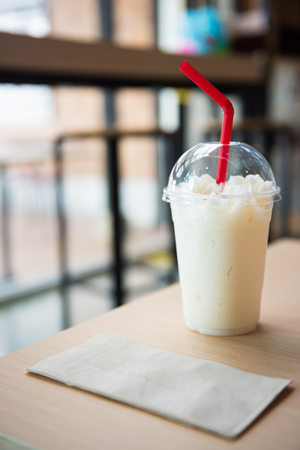 Milk smoothie in a glass on a wooden tableの写真素材