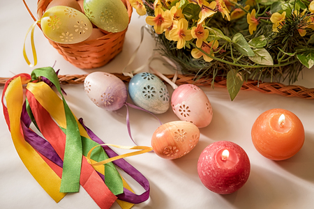 Easter, Easter decorations, painted eggs in a basket, and a backpack on a white backgroundの写真素材
