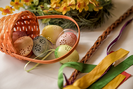 Easter, Easter decorations, painted eggs in a basket, and a backpack on a white backgroundの写真素材