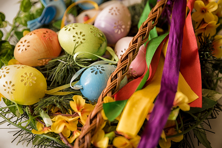 Easter, Easter decorations, painted eggs in a basket, and a backpack on a white backgroundの写真素材