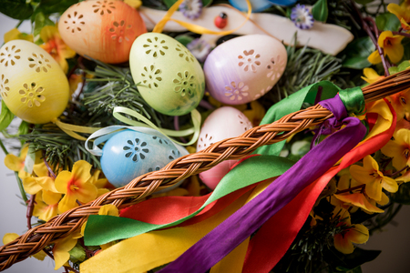 Easter, Easter decorations, painted eggs in a basket, and a backpack on a white backgroundの写真素材
