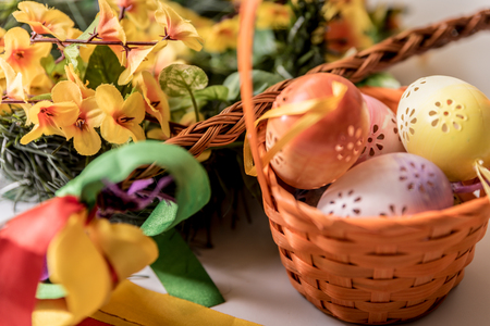 Easter, Easter decorations, painted eggs in a basket, and a backpack on a white backgroundの写真素材