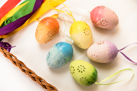Easter, Easter decorations, painted eggs in a basket, and a backpack on a white backgroundの写真素材