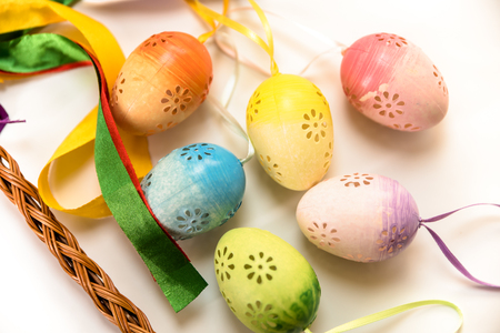 Easter, Easter decorations, painted eggs in a basket, and a backpack on a white backgroundの写真素材