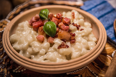 Slovak traditional dishes, potato gnocchi, bryndza, on wooden pancakes, potatoes, eggs. milk, sheep's cheeseの写真素材