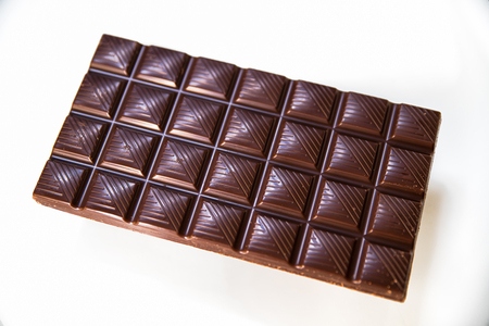 Chocolate. Black chocolate. A few cubes of black chocolate. Chocolate slabs spilled from grated chockolate powder.nutsの写真素材