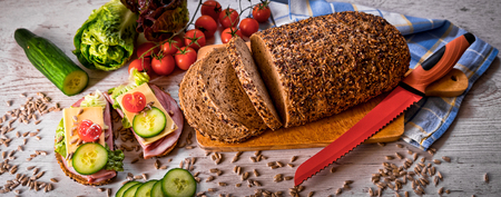 bread, fresh cereal bread with ham and vegetables, tasty healthy breakfast, top view, laid on the table, bannerの写真素材