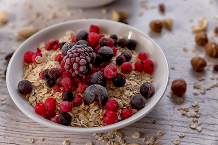 Oatmeal, nuts, woody fruit on a wooden background, ingredients, healthy foodの写真素材