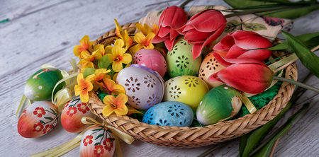 Easter, painted Easter eggs set in a bowl Easter decoration behind a white backgroundの写真素材