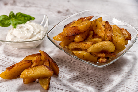 Roasted potatoes with herb sauce in glass dishの写真素材