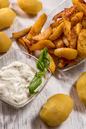 Roasted potatoes with herb sauce in glass dishの写真素材