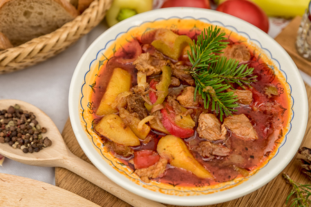 Can goulash with divas placed on the table of ingredients - meat, pepper, tomato, spices, potatoes, garlic, onion recipe for the preparation of traditional European foodの写真素材
