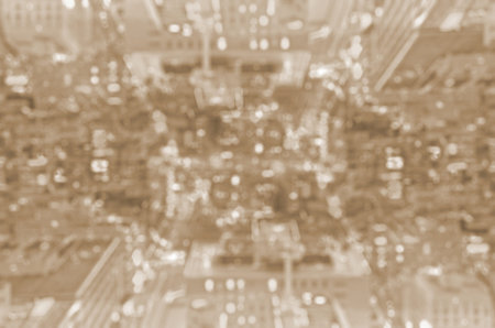 Defocused bokeh lights of buildings in blur background. Sepia toned.