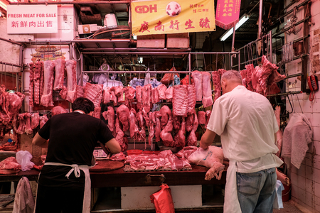 NORTH POINT, HONG KONG - MARCH 30, 2018 : Two butchers selling fresh meat at local market in North Point district, Hong Kong.のeditorial素材