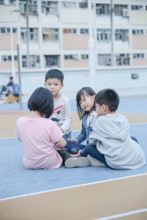 WONG TAI SIN, HONG KONG - MARCH 30, 2018 : Children sitting on basketball court at Choi Hung Estate in Hong Kong.のeditorial素材