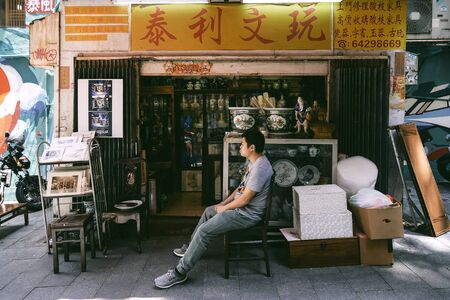 SHEUNG WAN, HONG KONG - MARCH 31, 2018 : Unidentified man sell chinaware in front shop on Hollywood Road in Sheung Wan district, Hong Kong.のeditorial素材