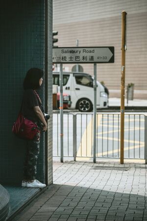 TSIM SHA TSUI, HONG KONG - APRIL 01, 2018 : Unidentified woman waiting near Salisbury Road in Tsim Sha Tsui, Hong Kong.のeditorial素材
