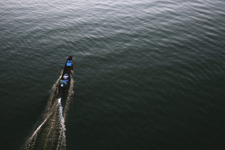 Traditional long tail boat sailing with the driver on the river in Sangkhlaburi, Kanchanaburi,...