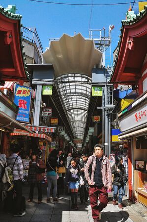 TOKYO, JAPAN - APRIL 05, 2014 : Tourists walk at Nakamise Dori in Sensoji shrine. Nakamise Dori has numerous stores lined up from Kaminarimon Gate to Hozomon Gate at Senso-ji.のeditorial素材
