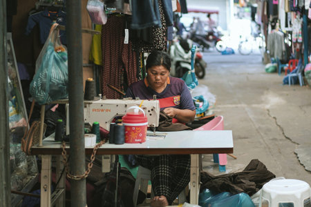 SAKAEO, THAILAND - JANUARY 08, 2019 : Unidentified woman sewing in a small tailor shop at Rong Kluea...